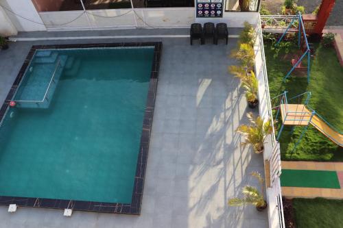 an overhead view of a swimming pool with palm trees at Sunshine Resort in Surai