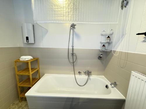 a bath tub with a shower in a bathroom at JUNX Bude in Marl