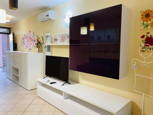 un soggiorno con una grande TV a schermo piatto a parete di SUITE GARDEN-MARINA SVEVA a Marina di Montenero