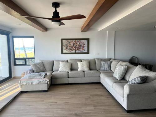 a living room with a couch and a ceiling fan at Oceanfront Home in Rosarito Beach in Santa Mónica Sur