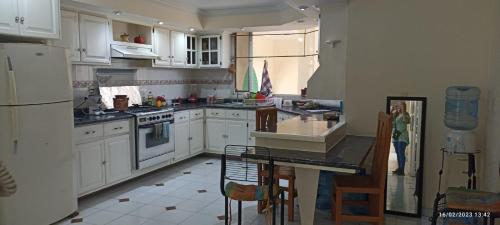 una cocina con armarios blancos y una mesa. en Hotel Teui Formarte, en Celaya