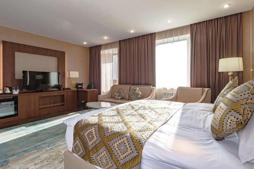 a hotel room with a bed and a television at Best Western Plus Astana Hotel in Astana