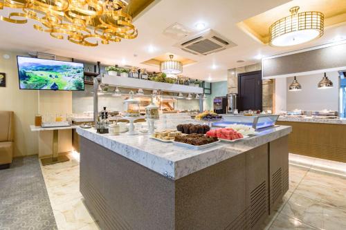 a breakfast buffet in a restaurant with food on a counter at Best Western Plus Astana Hotel in Astana