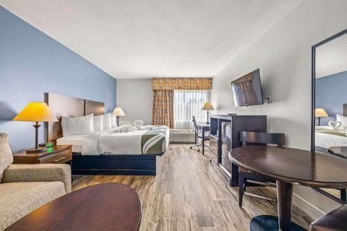 a hotel room with a bed and a table at Quality Inn & Suites Near Fairgrounds & Ybor City in Tampa