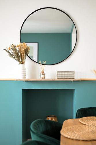 un miroir assis sur une étagère avec une table dans l'établissement L'Escale Bleue - Balcon privé - Vue mer, au Havre
