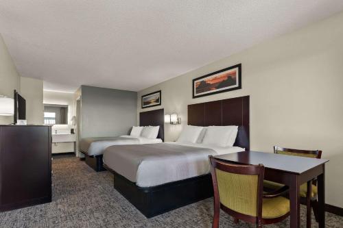um quarto de hotel com duas camas e uma mesa em Quality Inn & Suites Dublin em Dublin