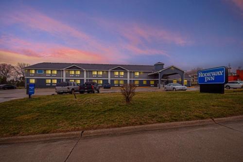 a building with a sign in front of a parking lot at Rodeway Inn Red Oak in Red Oak