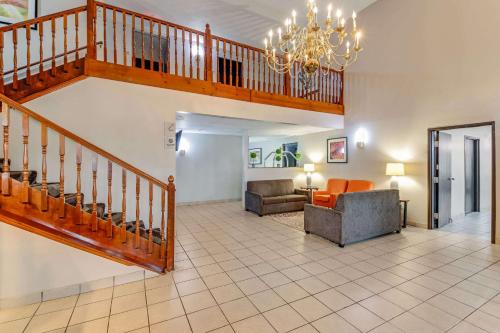 a living room with a staircase and a couch at Rodeway Inn Red Oak in Red Oak