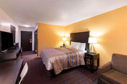 a hotel room with a bed and a couch at Rodeway Inn Red Oak in Red Oak