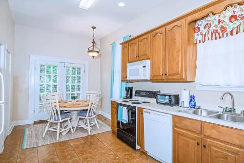 a kitchen with a table and a dining room at Americana Cottage Closest Historic BnB to Benning in Columbus