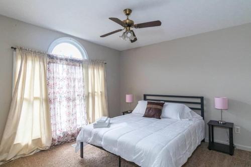 Un dormitorio con una cama y un ventilador de techo. en The Parkside Townhome Updated, Smoking Allowed, en Columbus