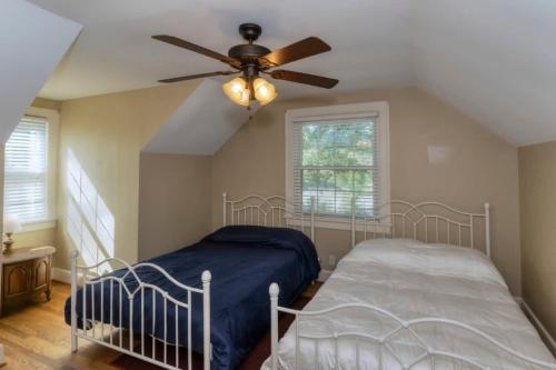 a bedroom with two beds and a ceiling fan at Near Fort Moore & Downtown - Our White House in Columbus