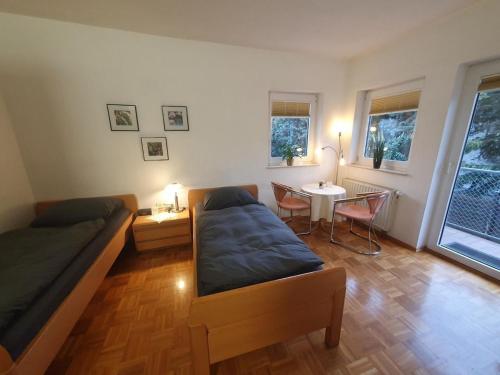 a room with two beds and a table and a tableablish at ABM Apartment 16 in Zwingenberg