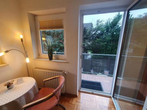 a room with a table and a balcony with a window at ABM Apartment 16 in Zwingenberg