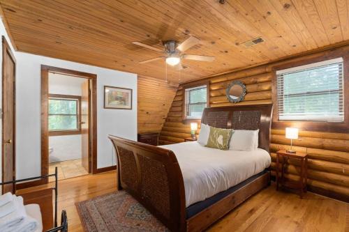 Campbell Log Cabin! Historic Charm, Modern Luxury في كلاركسفيل: غرفة نوم بسرير ومروحة سقف