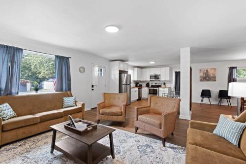 uma sala de estar com sofás e cadeiras e uma cozinha em Elegant in Noir- Midcentury Modern Vibes em Chattanooga
