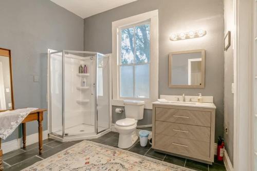 a bathroom with a shower and a toilet and a sink at Pretty Peach Palace-Historic, Mins to Downtown in Mobile