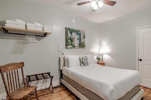 a white bedroom with a bed and a chair at Dauphin District Darling #1-Downtown, Restaurants in Mobile