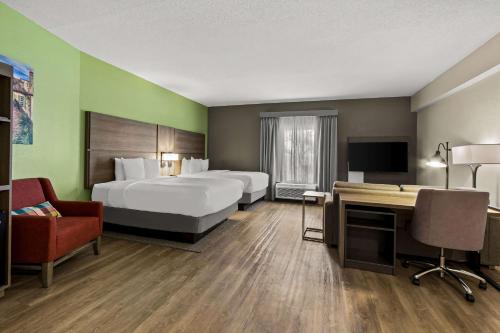 Habitación de hotel con 2 camas y escritorio en Comfort Suites Charleston West Ashley, en Charleston
