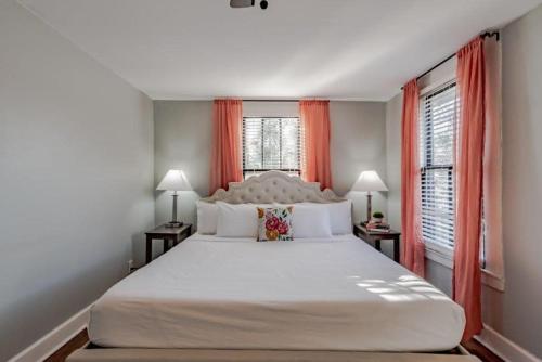 a bedroom with a large bed and two windows at Dauphin District Darling #4 Downtown, Dining in Mobile