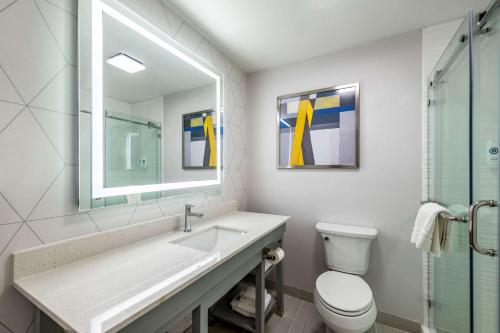 een badkamer met een wastafel, een toilet en een spiegel bij Comfort Suites Longview North in Longview