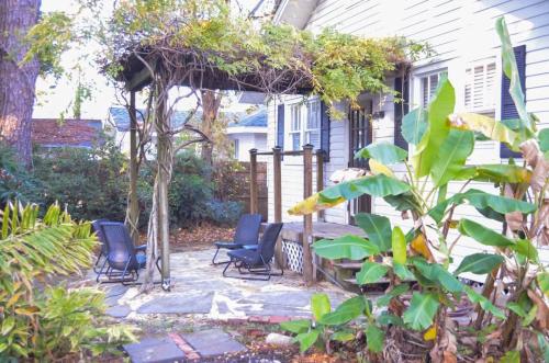 a patio with chairs and a pergola in front of a house at Perfectly Modern Craftsman- close to everything! in Mobile