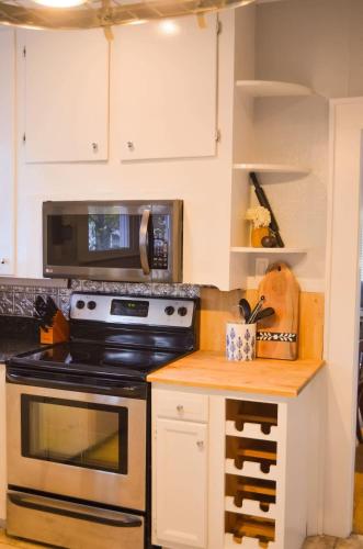 a kitchen with a stove and a microwave at Perfectly Modern Craftsman- close to everything! in Mobile