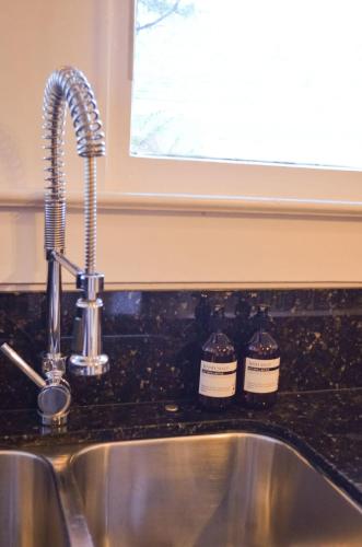 a kitchen sink with a faucet and two jars at Perfectly Modern Craftsman- close to everything! in Mobile