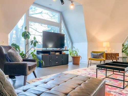 a living room with a tv and a large window at Rocket City's Original Space Dome in Huntsville