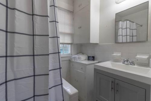 baño blanco con ducha y lavamanos en Midtown Magic- Back Unit- 10mins to Downtown, en Columbus