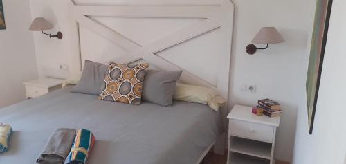 1 cama blanca con almohadas en el dormitorio en Oasis Waves House Papagayo, en Corralejo
