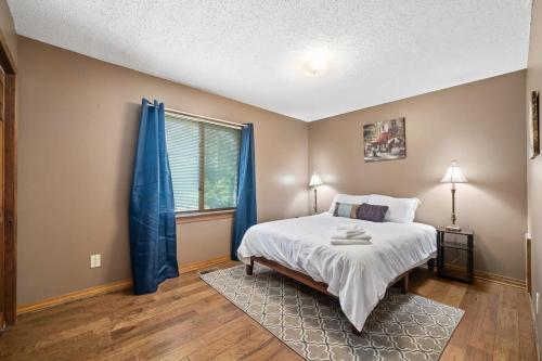 1 dormitorio con 1 cama y una ventana con cortinas azules en Backyard and Near Space Center - Jolly Green Giant, en Madison