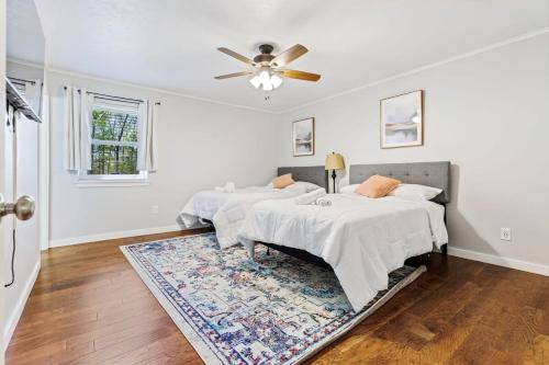 two beds in a white room with a ceiling fan at Close to Everything Dining Shopping & Hiking in Little Rock