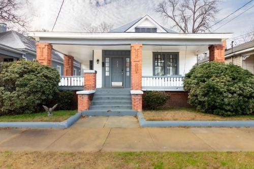 ein weißes Haus mit einer Veranda und einer blauen Tür in der Unterkunft Heart of Downtown Craftsman Walk to Shops Dining in Columbus