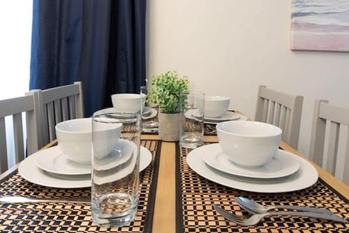 a table with plates and bowls and glasses on it at The Delightful Doubles- Unit E- Centrally Located in Columbus