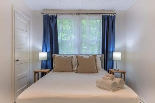 Un dormitorio con una cama grande con cortinas azules. en The Delightful Doubles- Unit E- Centrally Located, en Columbus