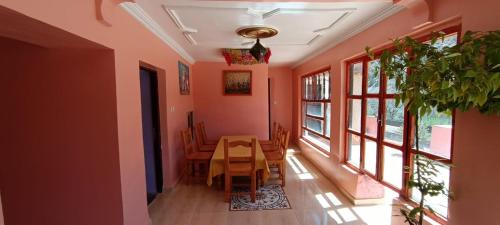 comedor con mesa y algunas ventanas en Gite Tamounte en Tabant