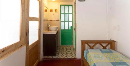 baño con puerta verde y lavamanos en 2 habitaciones y sala Histórico Edificio Pleno Centro en Mendoza