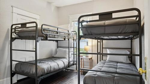 two iron bunk beds in a room with at Min to Downtown South Bend - St Joseph's on Leland in South Bend