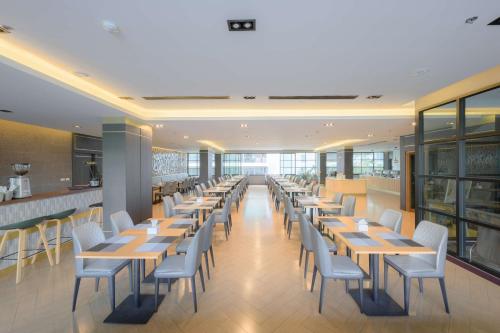 a row of tables and chairs in a restaurant at Lewit Hotel Pattaya, a member of Radisson Individuals in Pattaya South