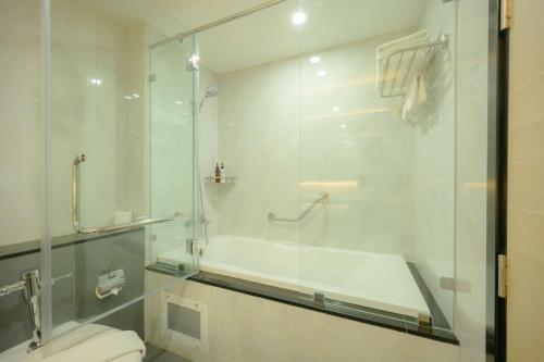 a bathroom with a glass shower and a toilet at Lewit Hotel Pattaya, a member of Radisson Individuals in Pattaya South