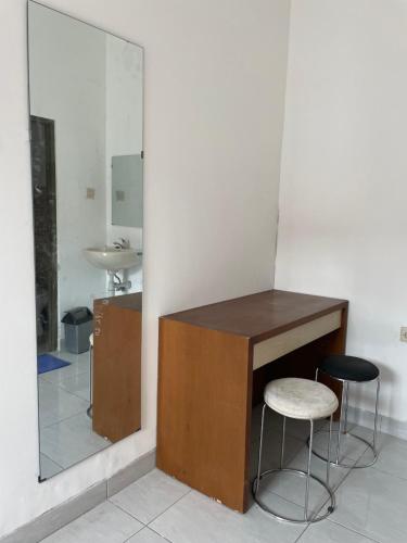 a bathroom with a counter and two stools and a mirror at MULIA INN Denpasar Imam Bonjol in Seminyak