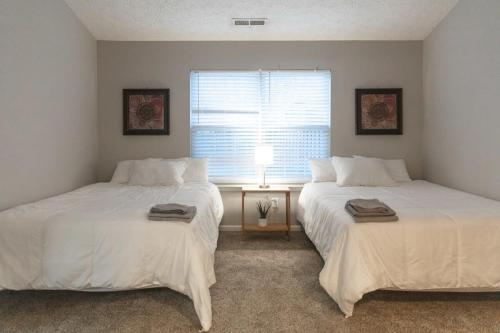 two beds in a room with a window at Chapel Hill Charmer- Close to Interstates in Indianapolis