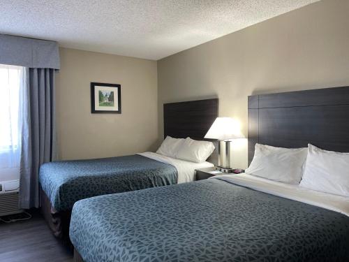 a hotel room with two beds and a window at Suburban Studios Columbia Northwest in Columbia