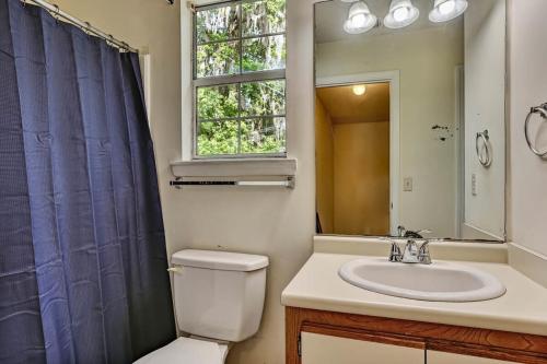 baño con aseo y lavabo y ventana en Fenced Yard Family Friendly Laurelwood Lodging, en Savannah