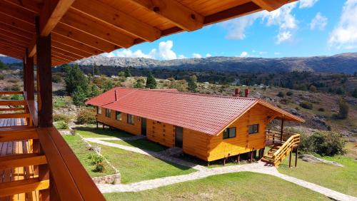 an image of a log cabin with a red roof at Complejo Apus in La Cumbrecita