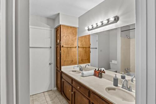 a bathroom with two sinks and a large mirror at Minutes from Tiger Stadium South Campus Hideaway in Baton Rouge