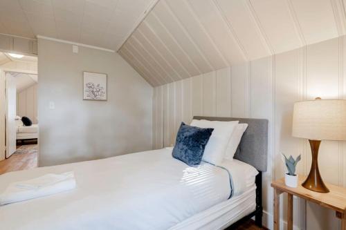 a bedroom with a white bed with a blue pillow on it at Mins to USC, Hospital, Zoo! Columbia Duet- 2 Units in West Columbia
