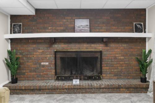 a brick fireplace with two plants in front of it at Two Kitchens Family Friendly in Forestdale in Birmingham