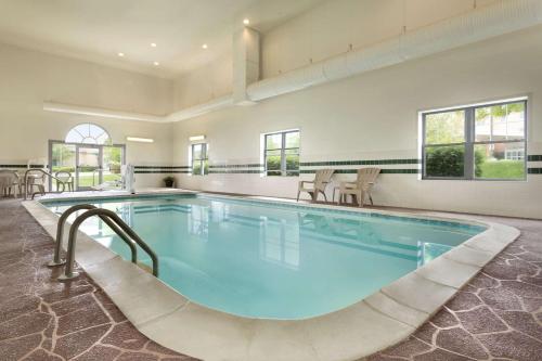 Country Inn & Suites by Radisson, Louisville East, KY في لويزفيل: مسبح كبير مع ماء ازرق في مبنى